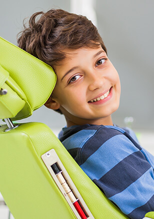 young smiling boy sitting in a dental chair