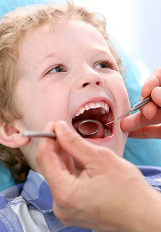 young boy having his teeth examined