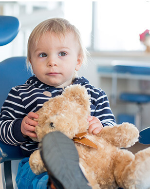 young boy holding his teddy bear