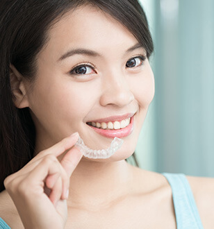 girl holding a whitening tray in her hand